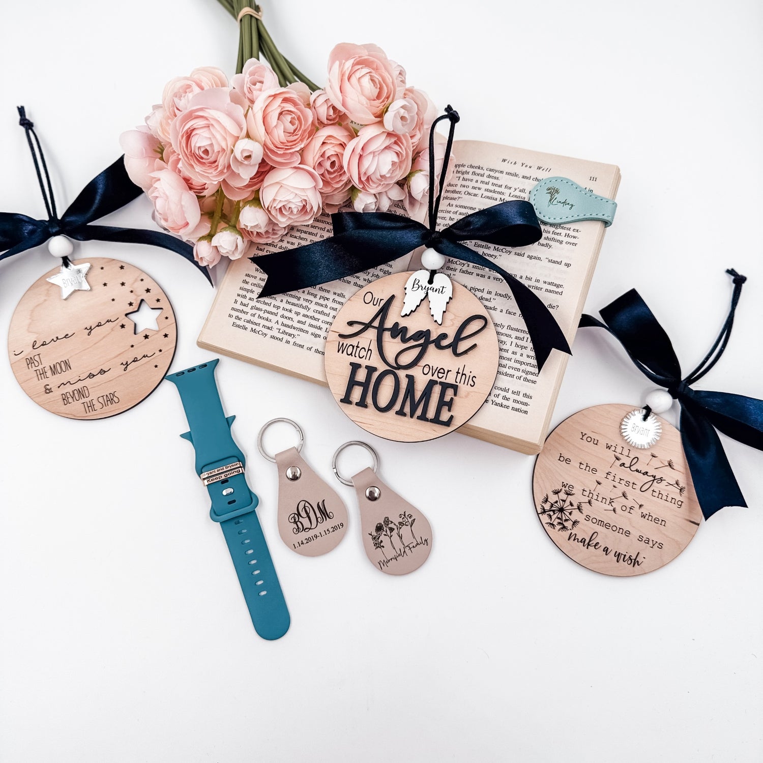 lat lay of personalized memorial keepsakes including engraved wood ornaments, leather keychains, and floral props — part of the Embellish My Heart “Keepsakes to Honor Their Memory” collection.